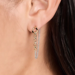 Gros plan sur les boucles d'oreilles à chaîne pendante dorée 18 carats avec oxydes de zircon