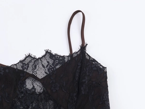 Detailed close-up of intricate black floral lace fabric with brown satin straps and lining