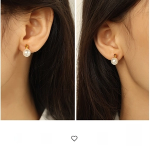 Detail view of elegant 8mm white pearl stud earrings with gold metal accents on model