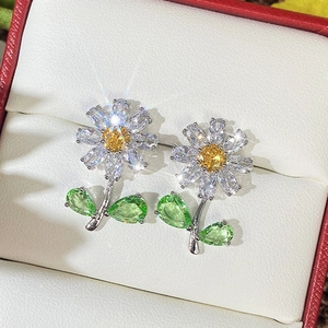 Elegant daisy stud earrings with yellow center and green leaf stones in silver setting