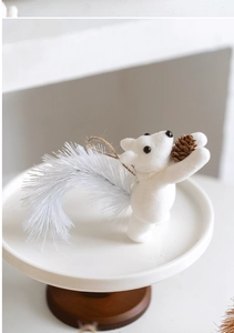 Détail d'un écureuil floqué blanc avec pomme de pin réelle et boucle en ficelle
