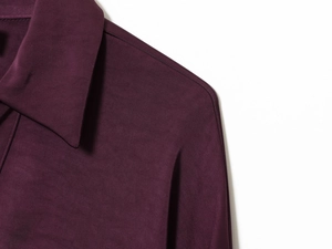 Détail de chemise en satin violet profond avec texture sergée et couture de col