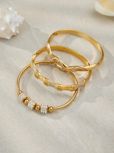 Détail du lot de 3 bracelets plaqués or 18k avec zircons blancs sur fond de sable fin
