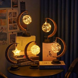 Detailed view of four crescent moon-shaped LED lamps with warm light and jute rope wrapping