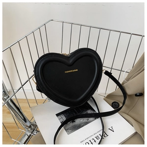Elegante borsa a tracolla in pelle nera a forma di cuore in un cestino di metallo