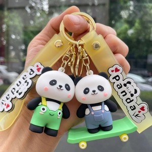 Close-up of panda keychains with colorful overalls on skateboards and yellow straps