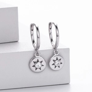 Close-up of silver sterling star earring with white zircon on a white background