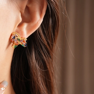 Side view of model wearing vintage golden stud earrings with colorful zircon stones