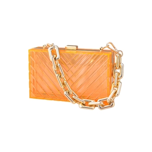 Minimalist orange acrylic clutch bag with bold gold chain strap for evening events