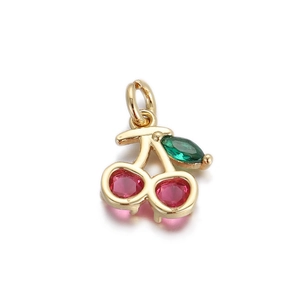 Detailed view of a 14k gold cherry pendant with red and green inset gemstones