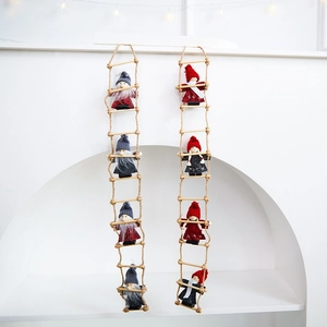 Handmade wool felt Christmas gnome figures on wooden rope ladders for festive decor