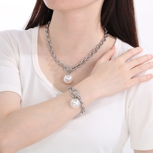 Detail of silver stainless steel necklace and bracelet set with large white pearls