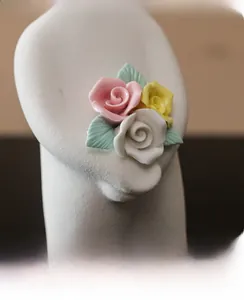 Macro view of ceramic rose decor featuring pink, yellow, and white porcelain petals