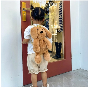 Detail of plush cartoon puppy backpack showing soft brown faux fur texture on a child