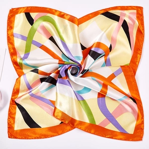 Detailed macro view of vibrant orange satin silk scarf with abstract geometric line patterns