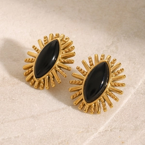 Detailed macro view of vintage sunburst earrings with black agate in gold stainless steel