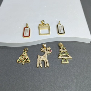 Detailed view of six gold Christmas charms with zircons and Merry Christmas pendants