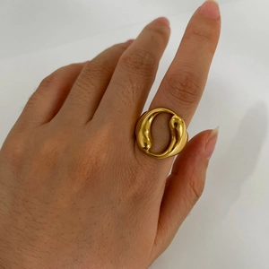 Anello dorato a doppia goccia d'acqua con design organico fluido indossato al dito