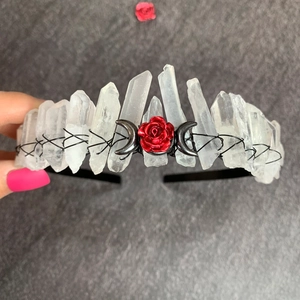 Detail of handmade clear crystal crown featuring red roses and black crescent moon designs