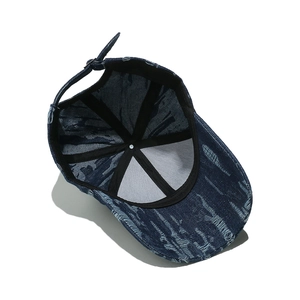 Detail view of denim baseball cap with adjustable metal buckle and inner sweatband