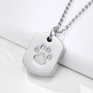 Macro detail of silver stainless steel pet paw print urn pendant with matching chain