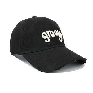 Detail of white groovy towel embroidery and distressed brim on black cotton baseball cap
