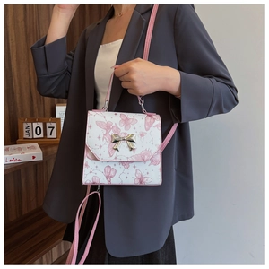 Detail of square white PU handbag with pink butterfly print and silver bow buckle