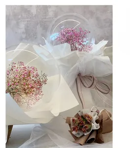 Close-up of clear 18-inch bubble balloon with pink gypsophila flowers and white mesh wrap