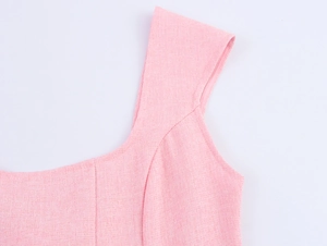 Detail shot of pink tweed dress shoulder strap and neckline with woven texture