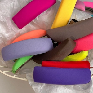 Close-up of vibrant ribbed fabric headbands stacked in a white metal basket