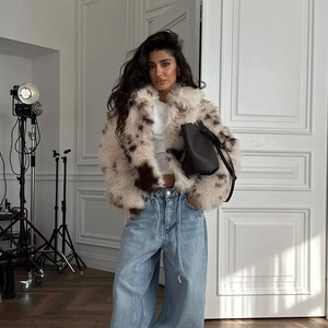 Women's faux fur jacket with animal print and wide-leg jeans in fashion studio