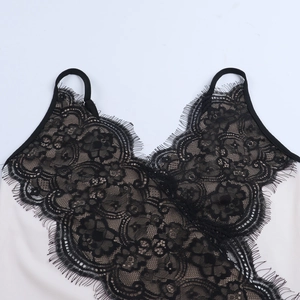 Detail of V-neck lace patchwork with eyelash lace trim on cream-white camisole dress