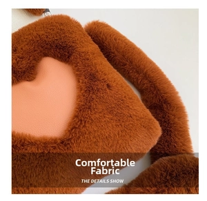 Dettaglio della trama in peluche marrone con una toppa in pelle rosa a forma di cuore