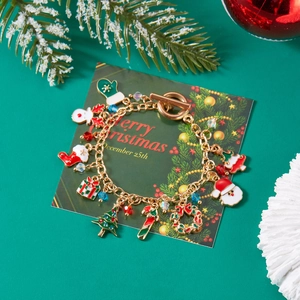 Golden Christmas charm bracelet with Santa Claus and Reindeer pendants on green festive card