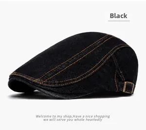 Detail of black denim flat cap featuring orange double stitching and copper side buckle