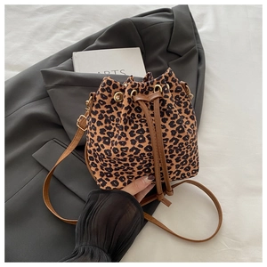 Détail du sac seau léopard avec fermeture à cordon et bandoulière réglable