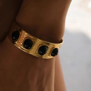 Vintage gold-plated wide cuff bangle with four oval black gemstones and ribbed texture