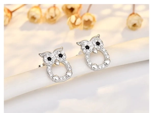 Macro detail of owl stud earring with silver plating and shimmering pavé zirconia stones