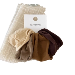 Set of four seamless high-elastic hair ties in neutral earth tones on linen fabric