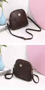 Detail of dark brown seashell crossbody bag with quilted rhombic texture and butterfly emblem