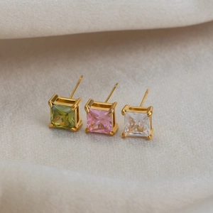 Macro shot of square cut zircon stud earrings in green pink and white with gold finish