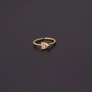 Detail of adjustable gold ring featuring a heart-shaped zircon and beaded texture