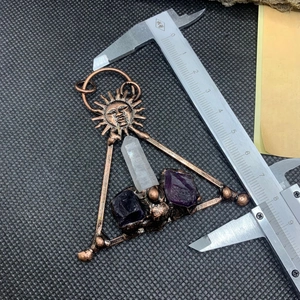 Close-up of amethyst sun pendant size measurement with metal caliper on black mat