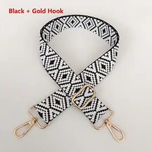 Close-up of black and white geometric diamond strap with golden metal swivel hooks