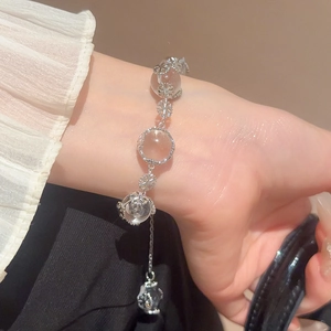 Close-up of minimalist crystal snowflake beaded bracelet on wrist in warm beige setting