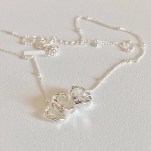 Detailed view of silver interlocking triple ring pendant necklace with zircon stones
