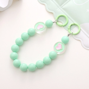 Detail showing mint green acrylic beads with pink heart accents and metal spring buckles