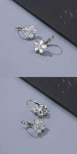 Detail view of silver floral earrings with sparkling teardrop-shaped zircons and lever-back
