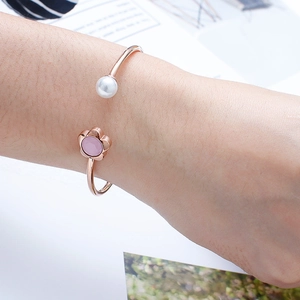 Rose gold flower open cuff bracelet with pink crystal and white pearl on woman's wrist