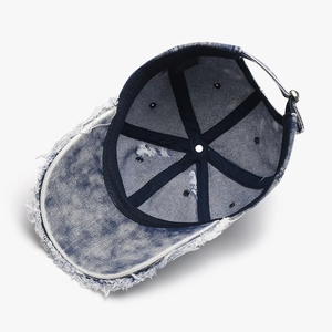 Distressed vintage blue washed denim baseball cap with heavy frayed edges and ripped details